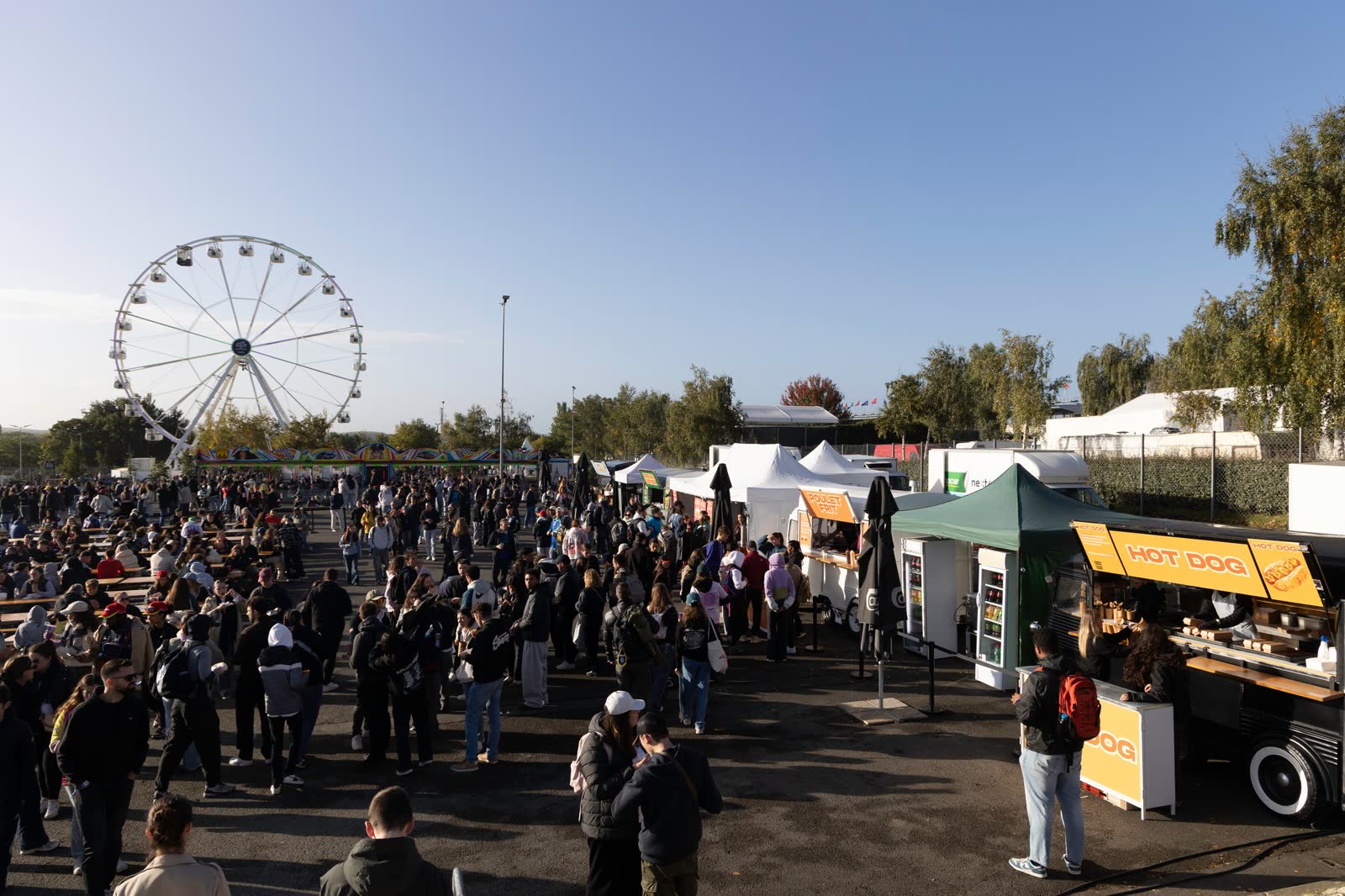 Allée de festival avec grande roue et food trucks